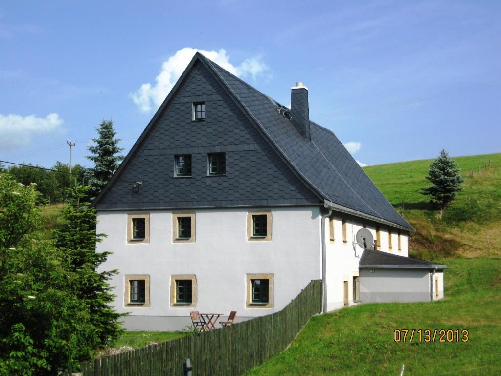 a large white house with a black roof at Ferienhof Herm in Glashütte