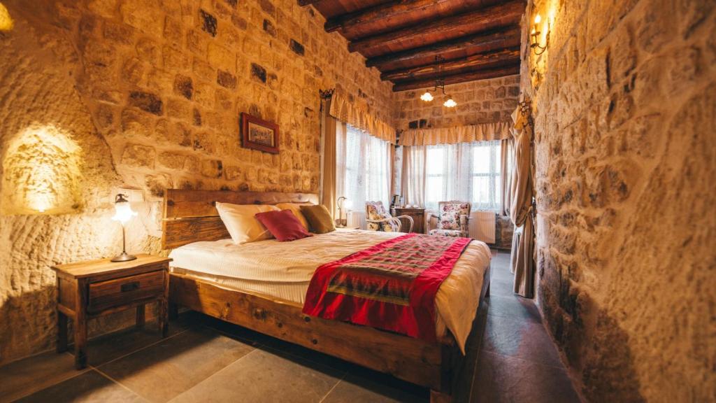 1 dormitorio con 1 cama en una pared de piedra en Cappadocia Old Houses en Nevşehir