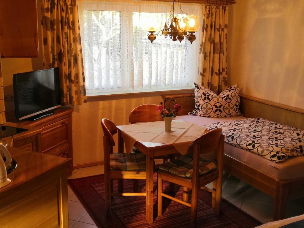 ein Esszimmer mit einem Tisch und einem Fenster in der Unterkunft Bungalow Poggendorf in Eldena