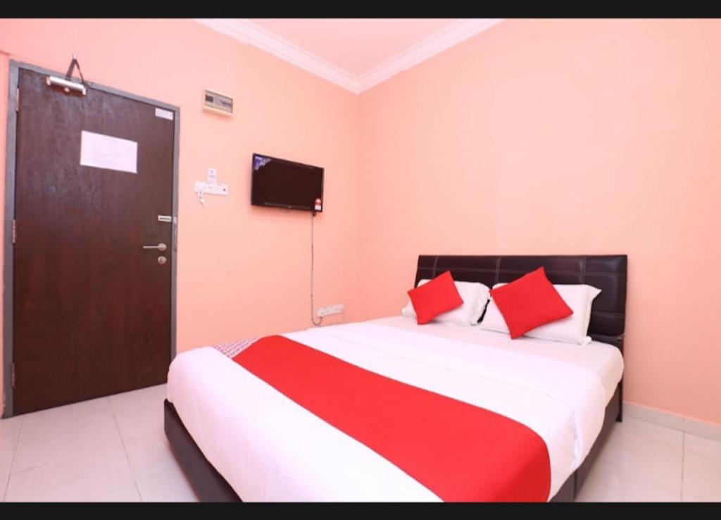 a bedroom with a bed with red pillows and a door at SA VILLA HOLIDAY INN in Kota Bharu