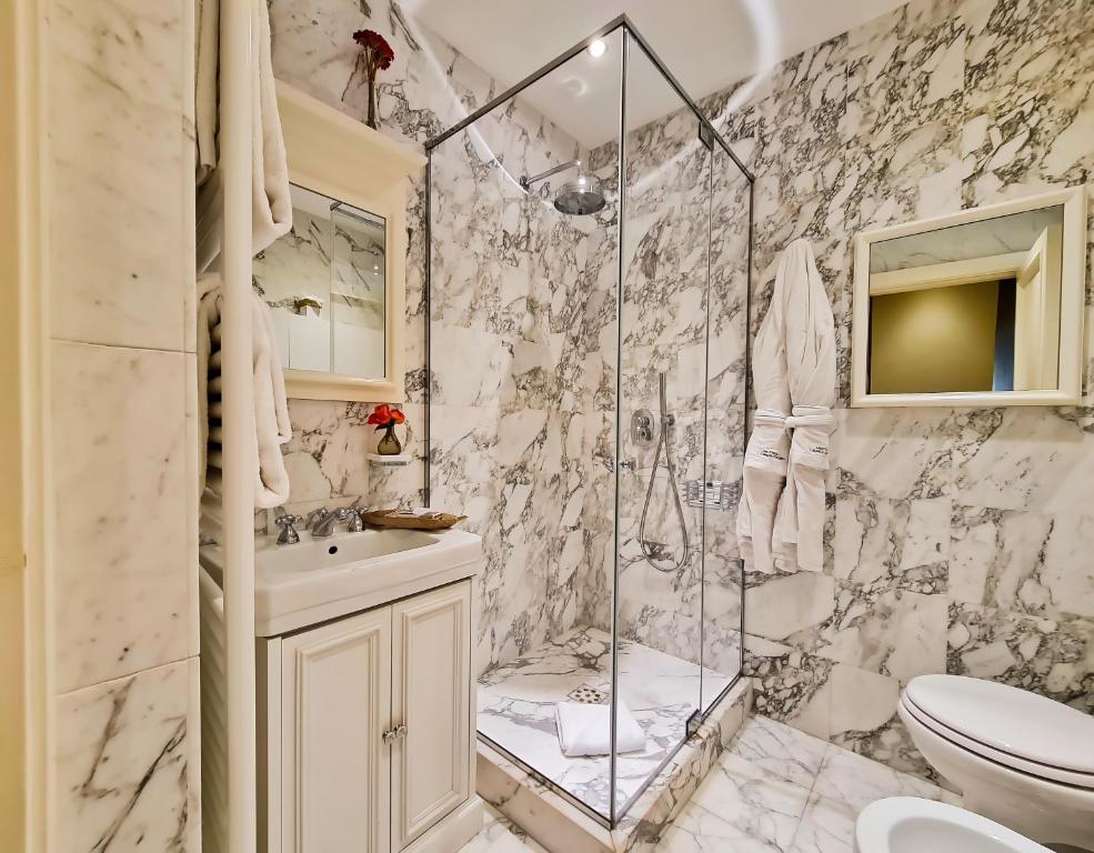 a bathroom with a shower and a toilet and a sink at Hotel Balestri - WTB Hotels in Florence