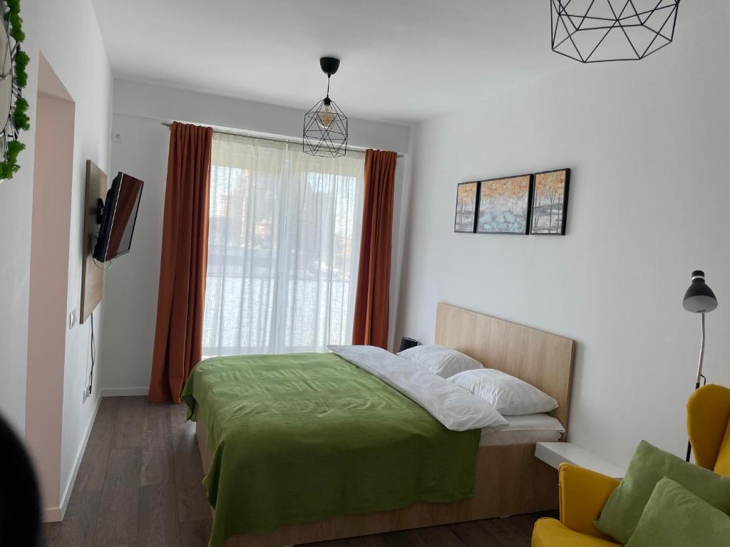 een slaapkamer met een groen bed en een raam bij Apartcentral in Baia Mare