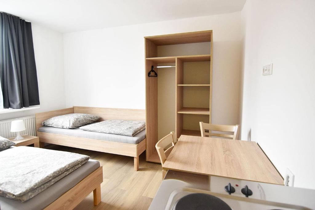 a small room with two beds and a table at Zimmer24Frei Boardinghouse in Cologne