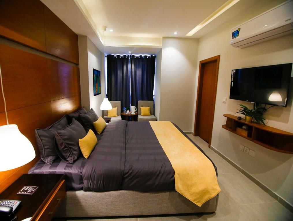 1 dormitorio con 1 cama grande y TV de pantalla plana en Space Express en Rāwalpindi