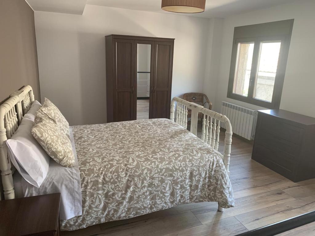 a bedroom with a bed with a white comforter at Dúplex Rural Casa Bergua in Arguis