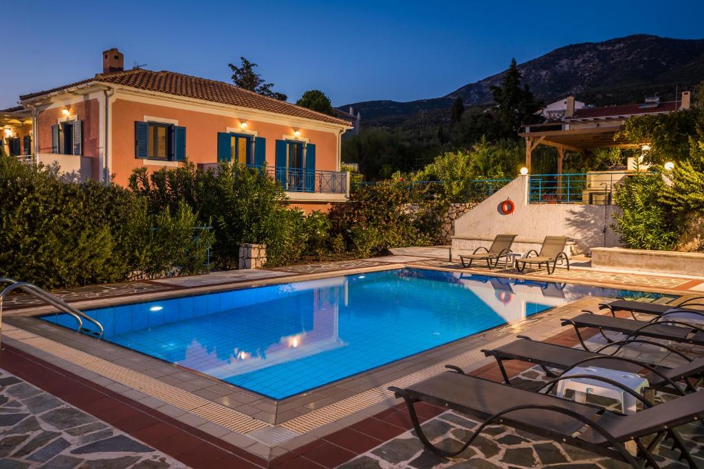 a swimming pool in front of a house at Villa Rudi in Trapezaki