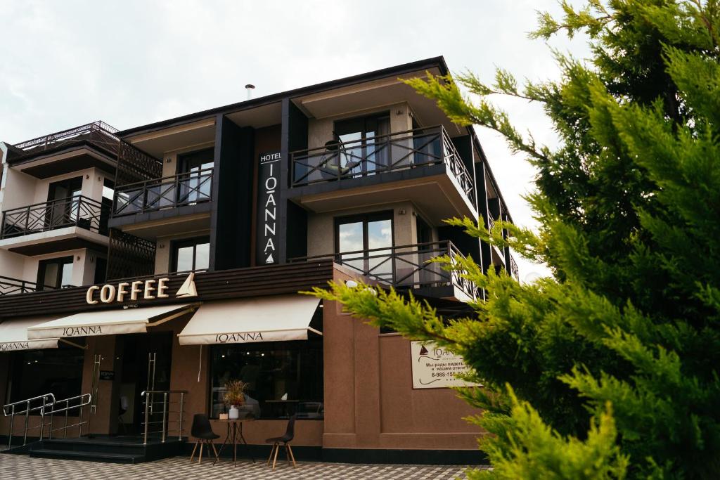 a building with a coffee shop on the side of it at Ioanna Boutique Hotel in Adler