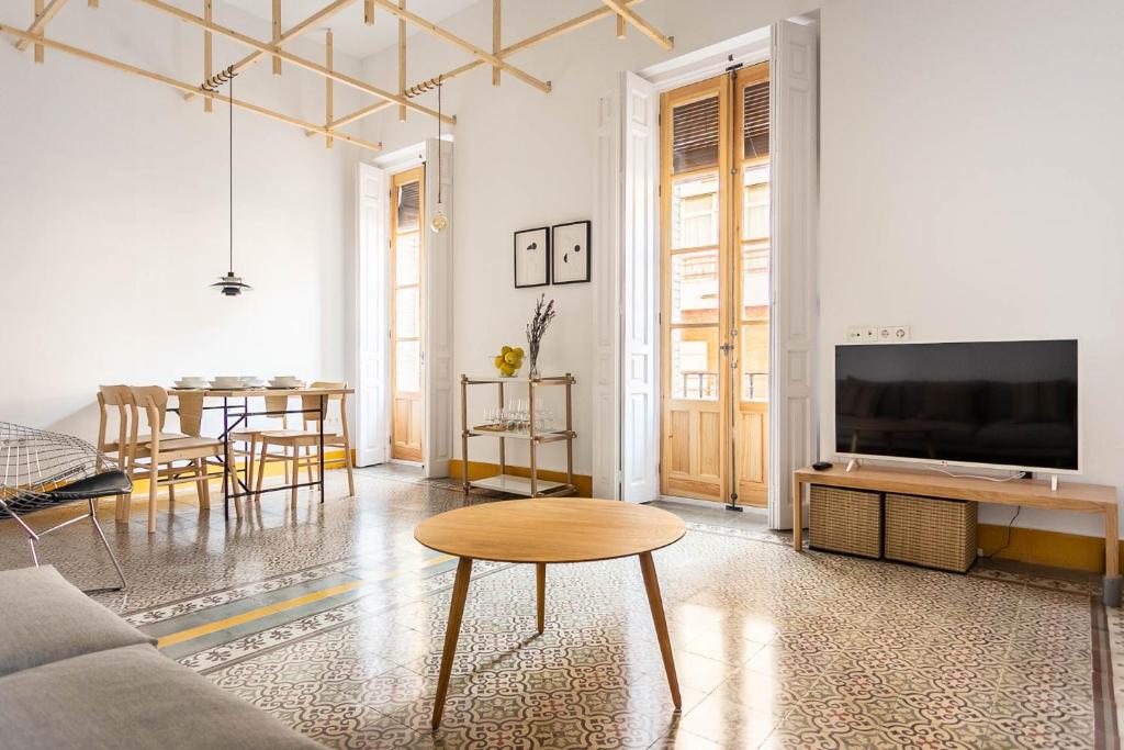 a living room with a couch and a table and a tv at Pop Art , Sunny Apartment near Santa Cruz in Seville