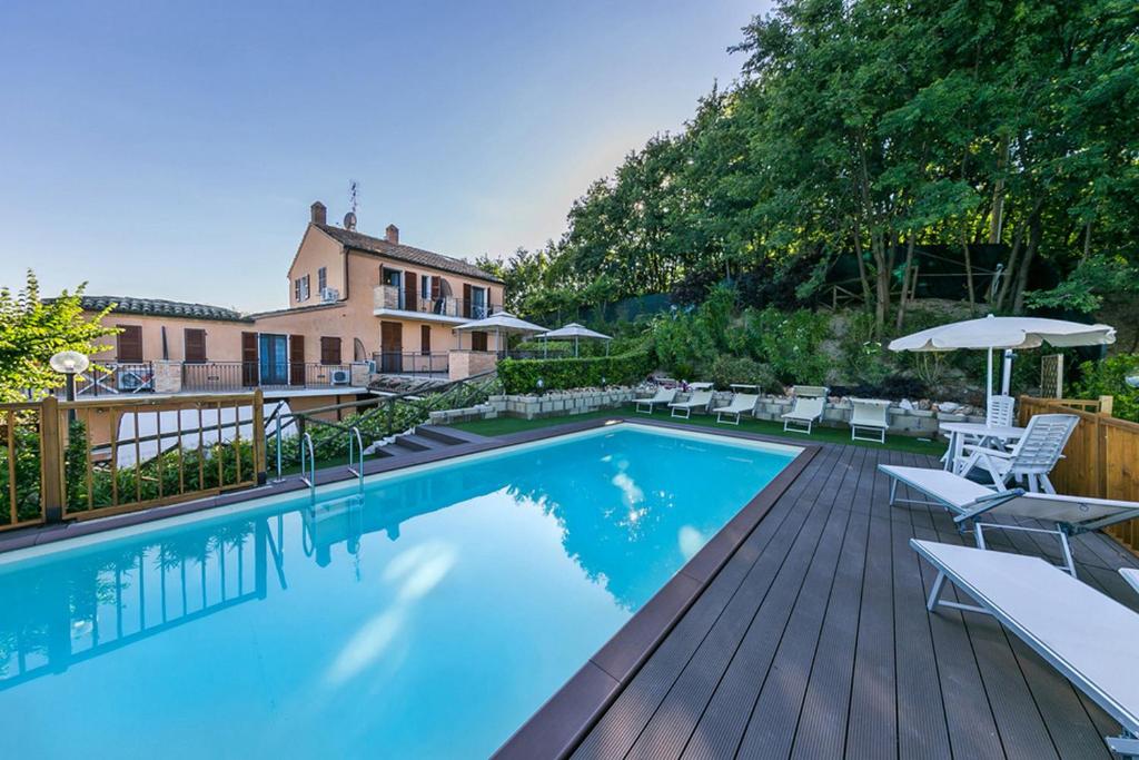 basen z leżakami i parasolami obok domu w obiekcie La casa di Carla w mieście Fermo