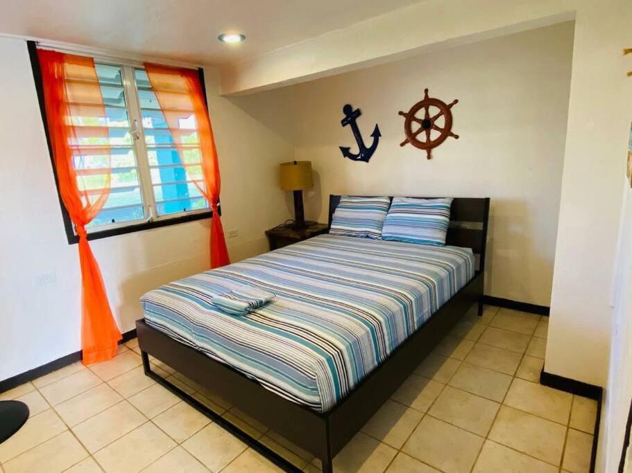 een slaapkamer met een bed met een anker aan de muur bij Free WIFI 1st Floor Apartment in Punta Santiago