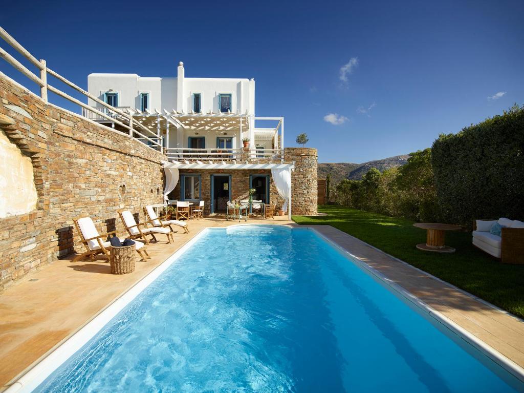 a swimming pool in front of a villa at Heliades Villas in Gavrio