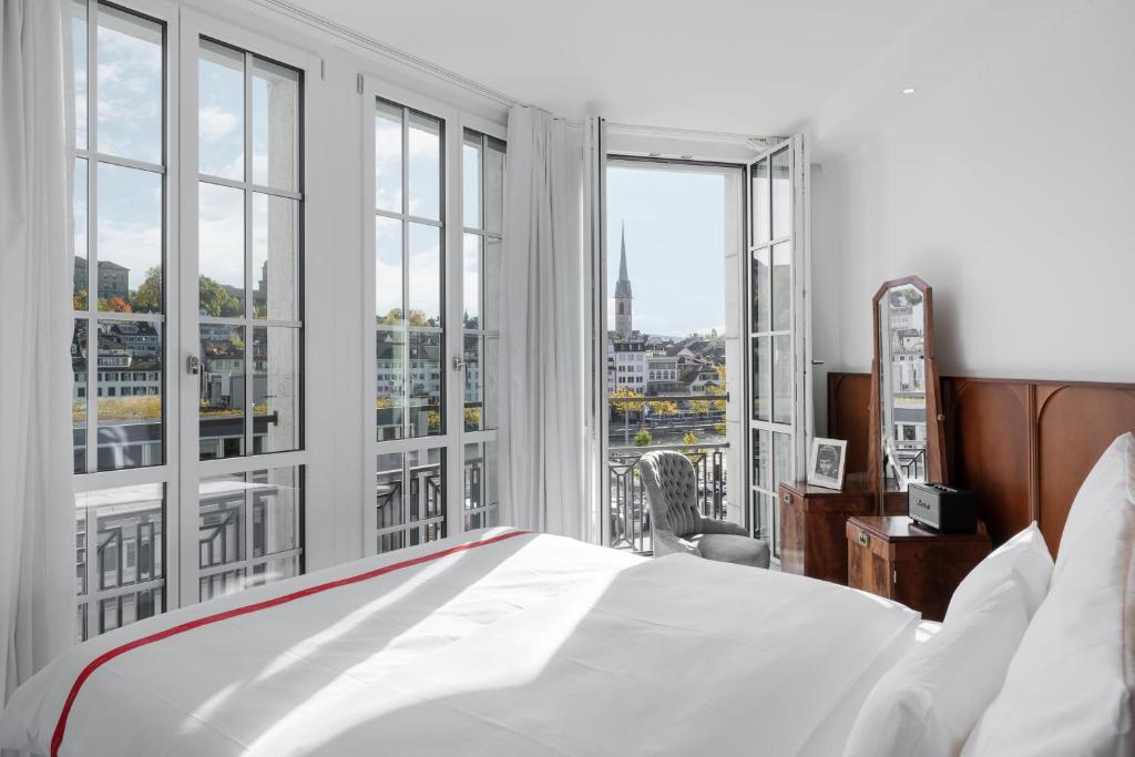 a bedroom with a bed and large windows at Ruby Mimi Hotel Zurich in Zürich