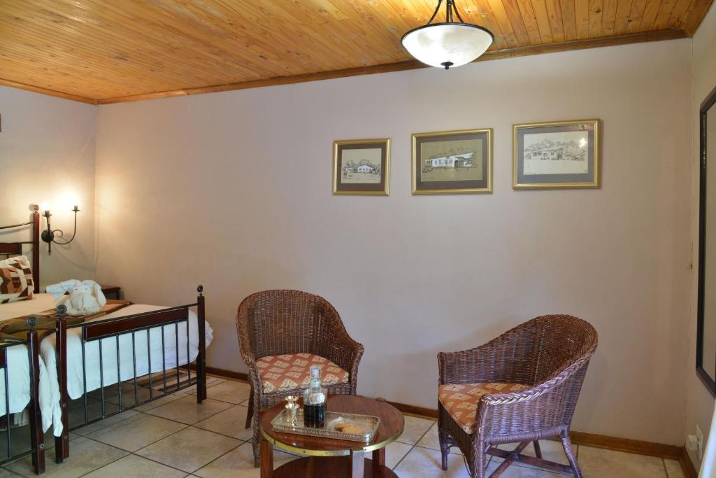 a living room with two chairs and a table at Kasane Self Catering in Kasane
