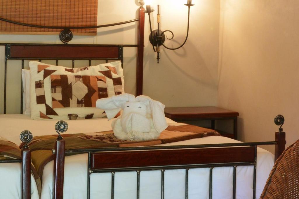 a bed with a stuffed animal sitting on it at Kasane Self Catering in Kasane