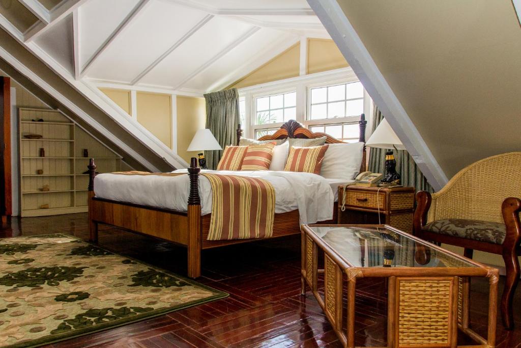 a bedroom with a large bed and a staircase at Cara Lodge Hotel in Georgetown