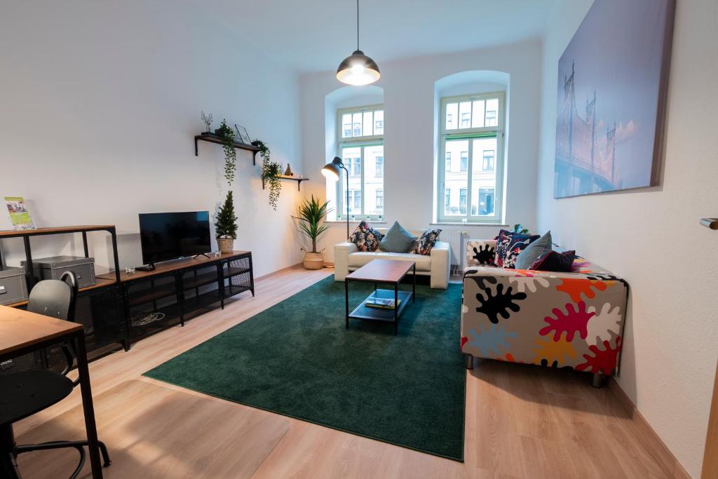 ein Wohnzimmer mit einem Sofa und einem TV in der Unterkunft Erdgeschoss auf dem gemütlichen Kaßberg in Chemnitz