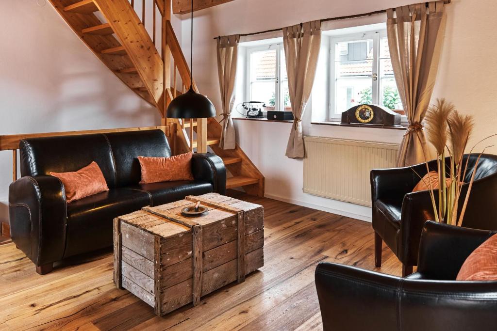sala de estar con muebles de cuero y mesa en Ferienhaus Lilace, en Böttingen