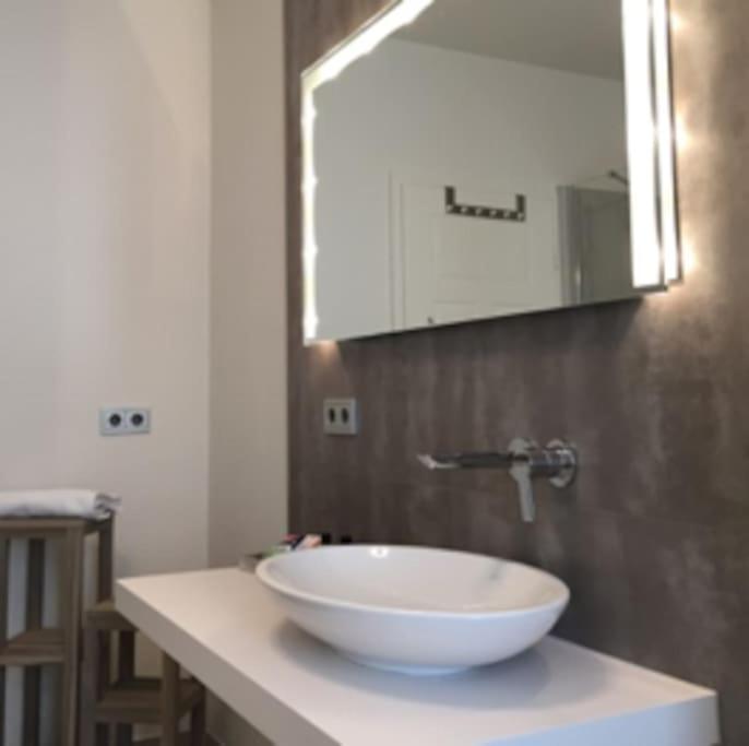een badkamer met een witte wastafel en een spiegel bij Gästehaus Ritter & Pacia, Ferienwohnung 2. Etage in Sangerhausen