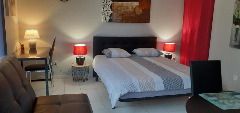 ein Schlafzimmer mit einem Bett mit zwei Lampen und einem Sofa in der Unterkunft Studio meublé 27m2 - Entrée privée in Demange-aux-Eaux