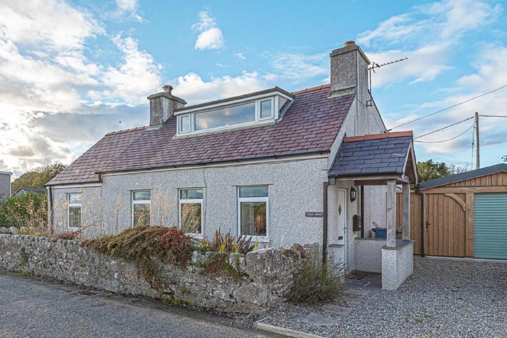 a white brick house with a window on top of it at Llys Awel in Llangadwaladr