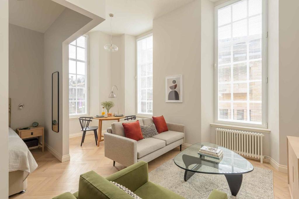 ein Wohnzimmer mit einem Sofa und einem Tisch in der Unterkunft Museum Apartments in Edinburgh