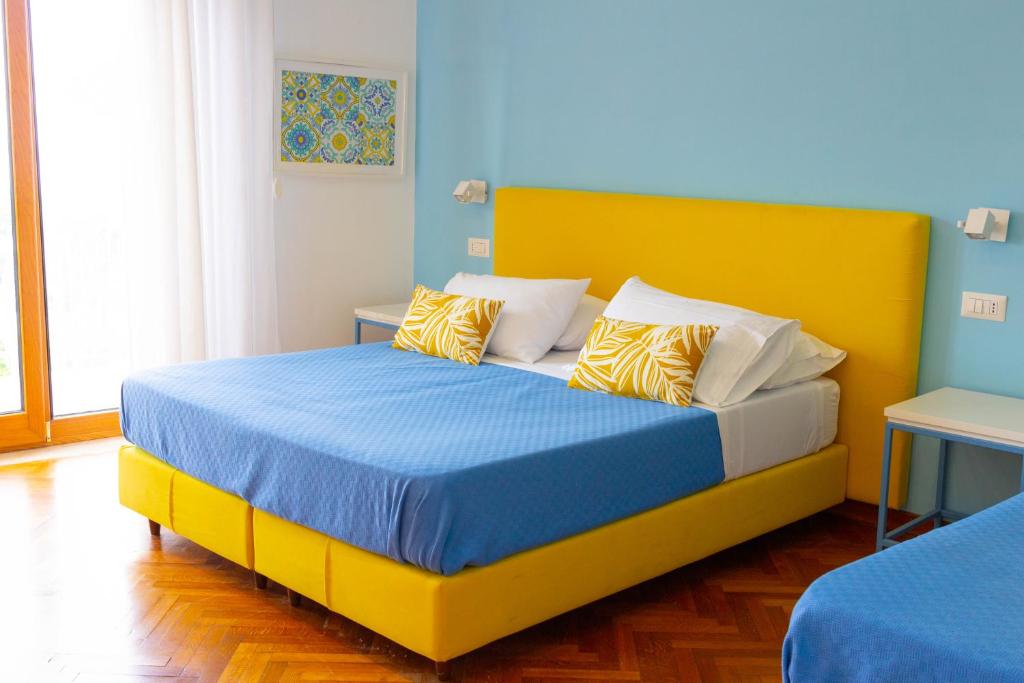 a bedroom with a yellow bed with blue and yellow pillows at Sorrento Central and Sea View Flats in Sorrento