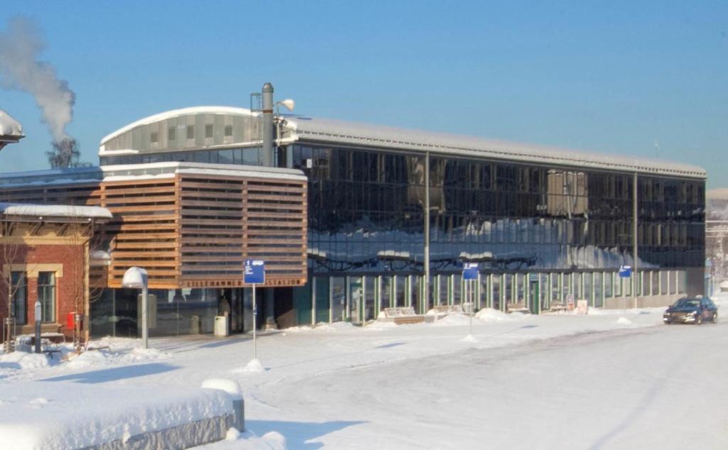 a building with a car parked in front of it at Lillehammer Hostel in Lillehammer