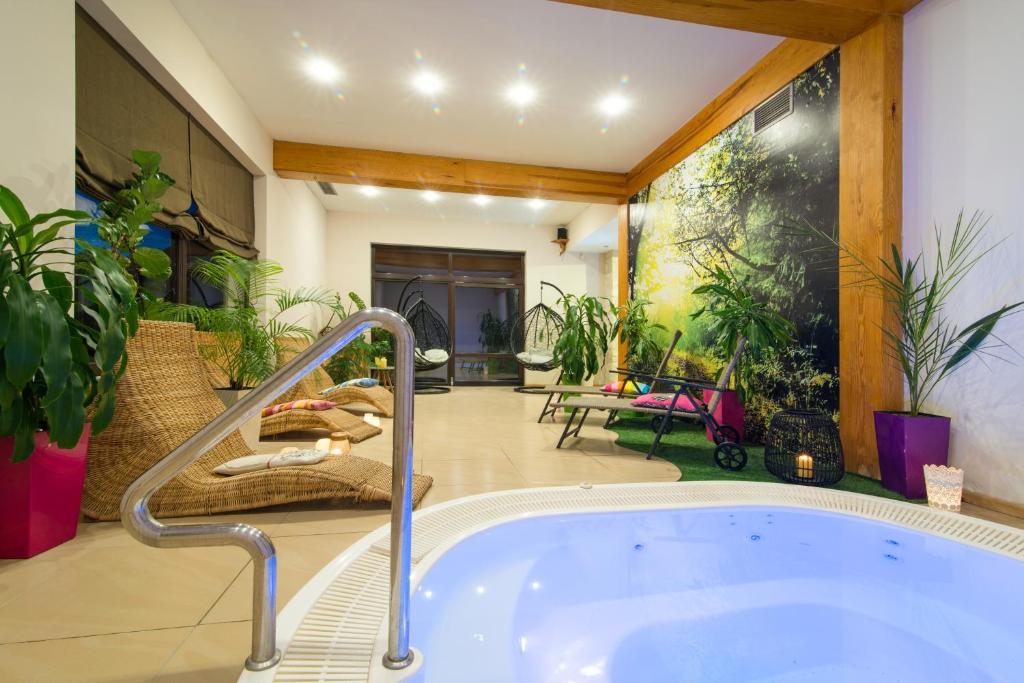 a jacuzzi tub in a room with plants at Balia Spa & Wellness in Kazimierz Dolny