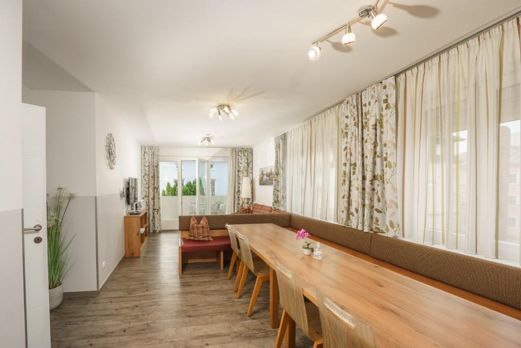 un comedor con una mesa larga y un sofá en Easyapartments Riverside, en Salzburgo