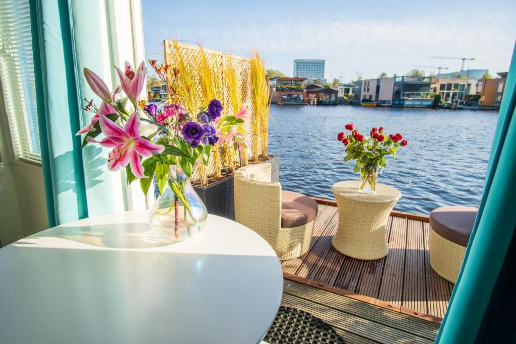 una mesa con jarrones de flores en un barco en The New Lake Boathouse, en Ámsterdam