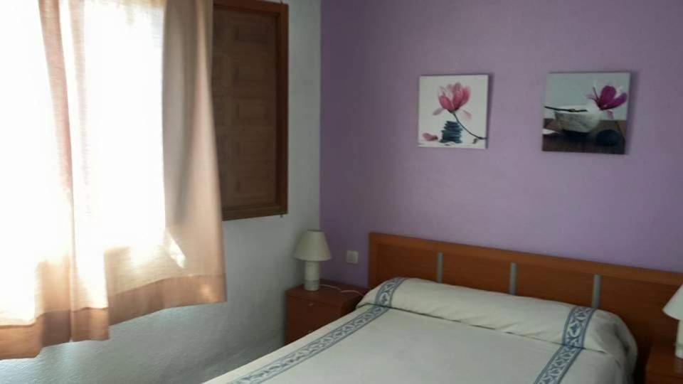 1 dormitorio con 1 cama y 2 cuadros en la pared en Manxalo, en Sant Mateu