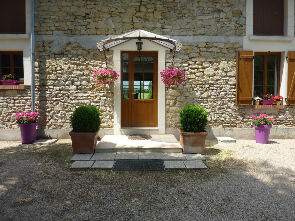 uma casa com dois vasos de plantas e uma porta de madeira em Chambres d'Hôtes de la Junchère em Saint-Hilaire-de-Court