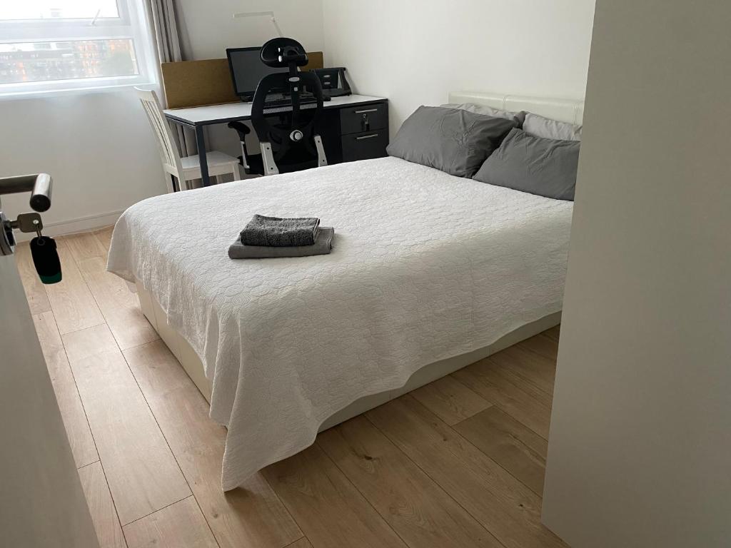 a bedroom with a bed with a desk and a chair at Private Bedroom with an Office Desk in a shared 2 bedroom flat in London