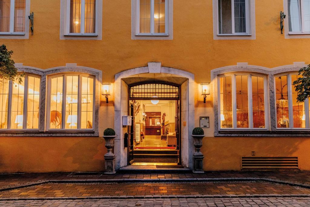 an orange building with a door and a staircase at Hotel Fletzinger in Wasserburg am Inn