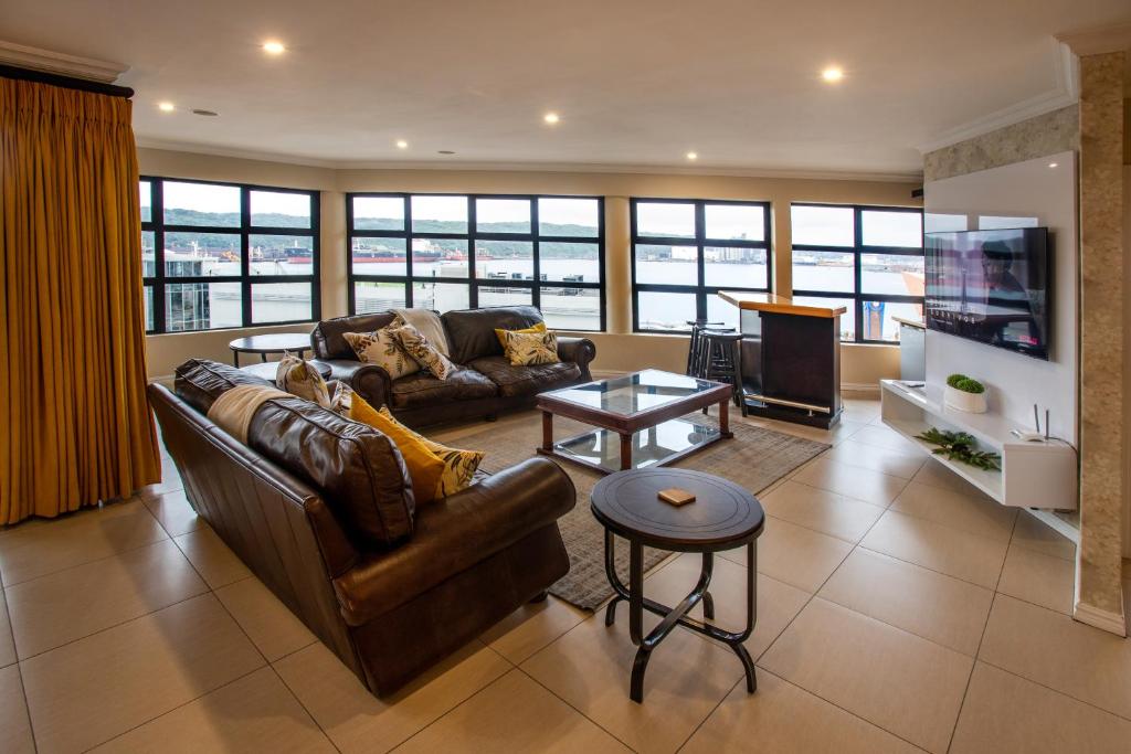 a living room with a couch and a tv at Stay at The Point - Peaceful Plentiful Penthouse in Durban