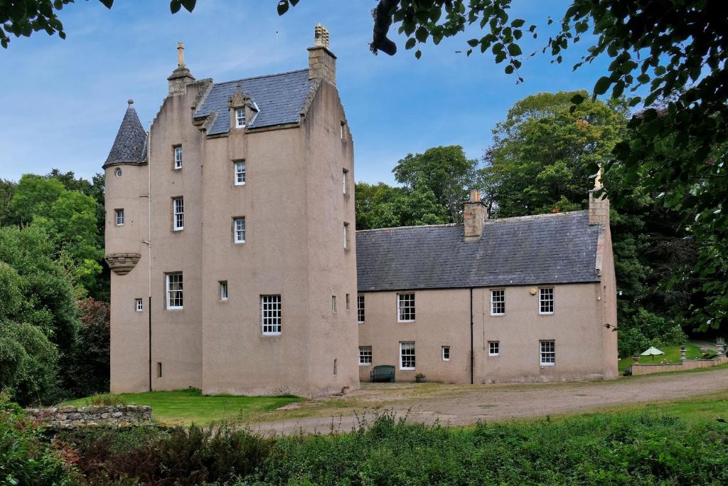 an old castle on a hill with trees at Lickleyhead Castle in Insch