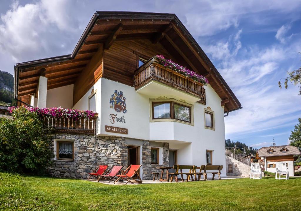 ein Haus mit einem Balkon und Stühlen im Hof in der Unterkunft Chalet Fisti in Stern