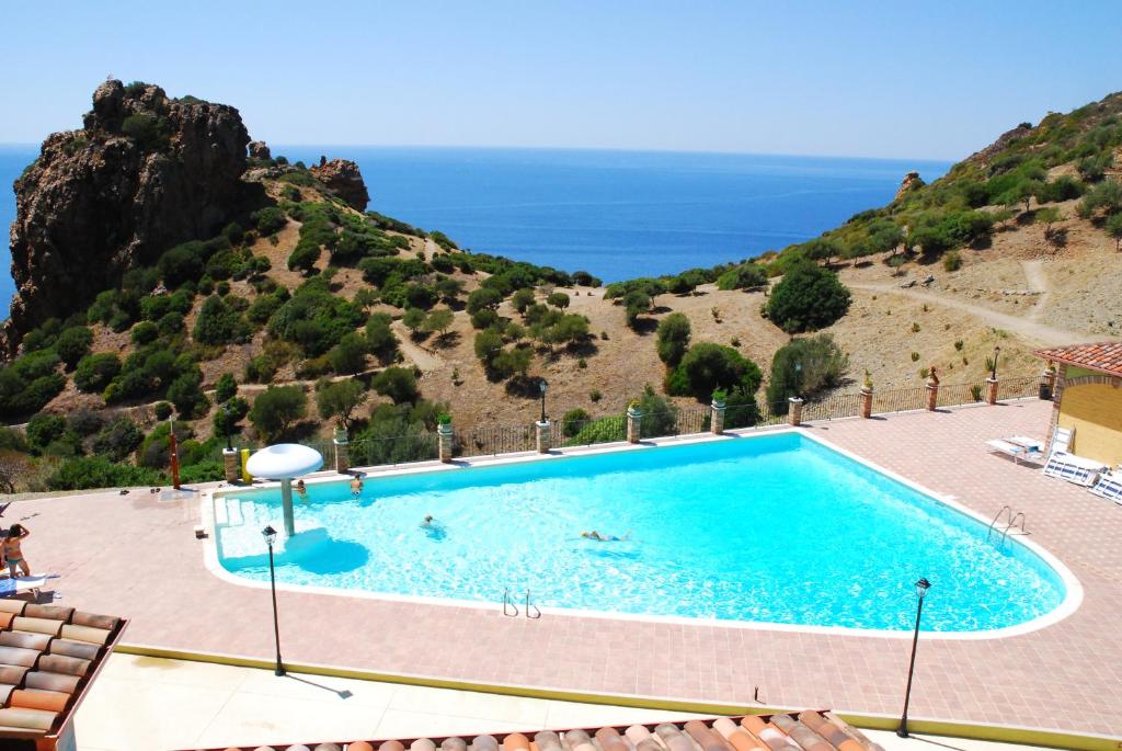 a swimming pool with a view of the ocean at L'Incanto Tanca Piras in Nebida