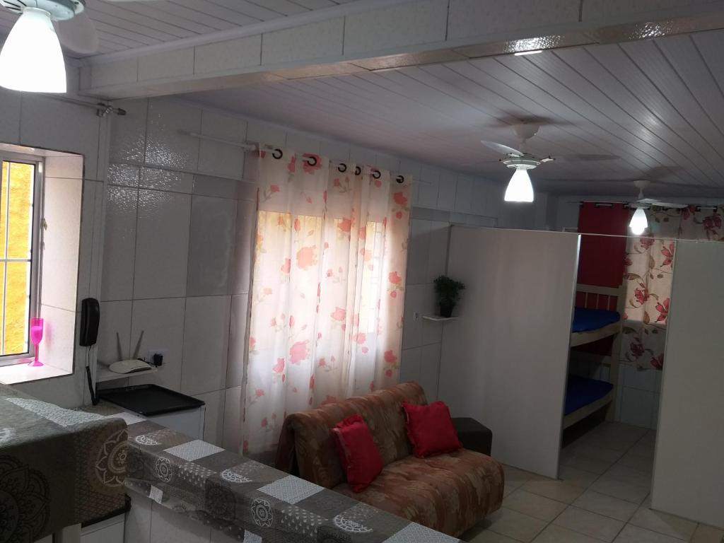 - un salon avec un canapé et une fenêtre dans l'établissement Kitnet para Temporada no Litoral SP, à Praia Grande