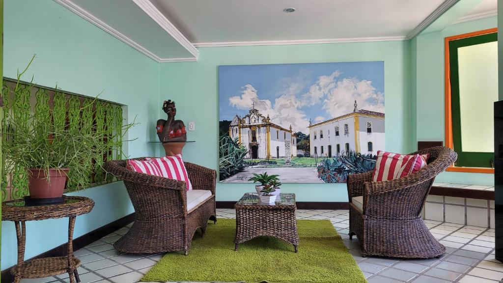 una habitación con 2 sillas y un cuadro en la pared en Hotel Terra Mater, en Porto Seguro