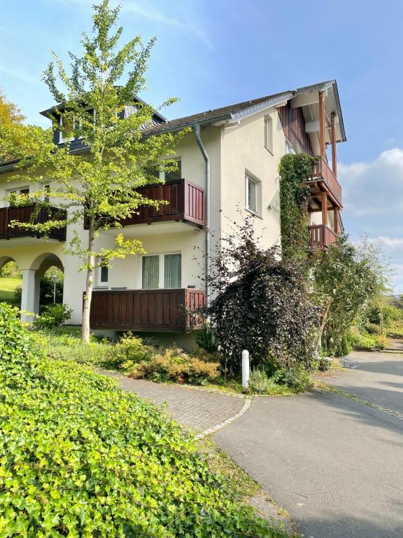 a building with a tree next to a street at DAS LOFT Hotel Hölsterloh in Brilon