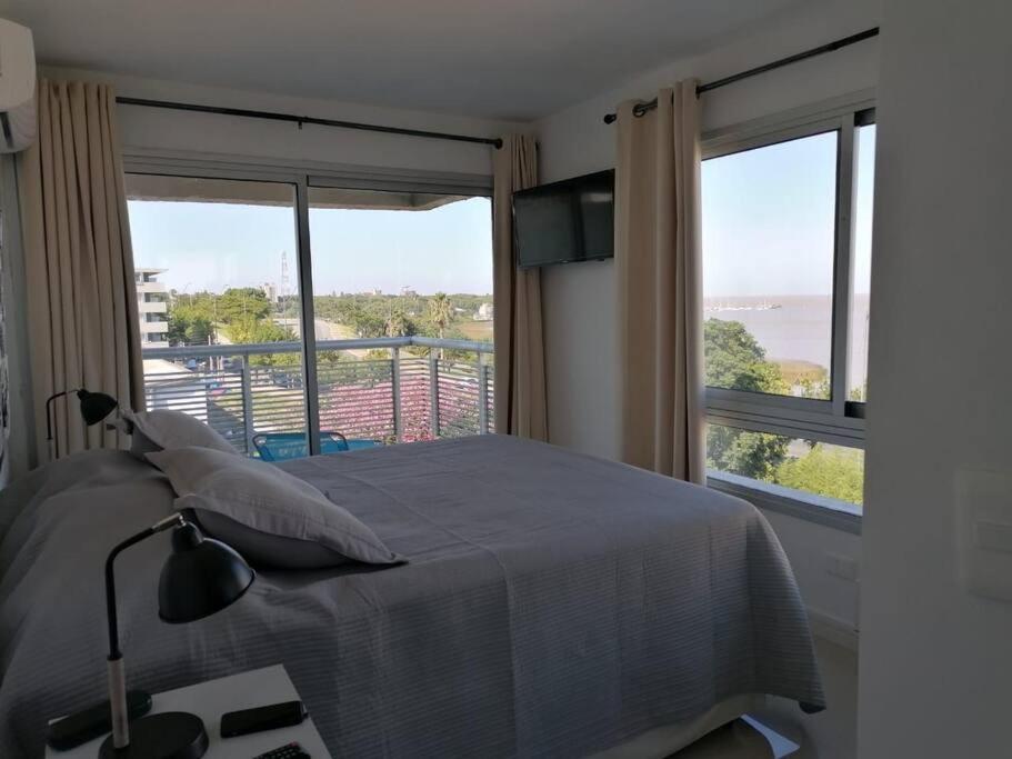 a bedroom with a bed and a large window at Solares de Araus 406 in Colonia del Sacramento
