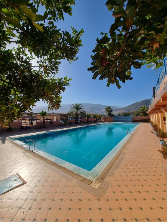 een zwembad in een resort met bomen bij L'oliveraie D'amizmiz in Amizmiz