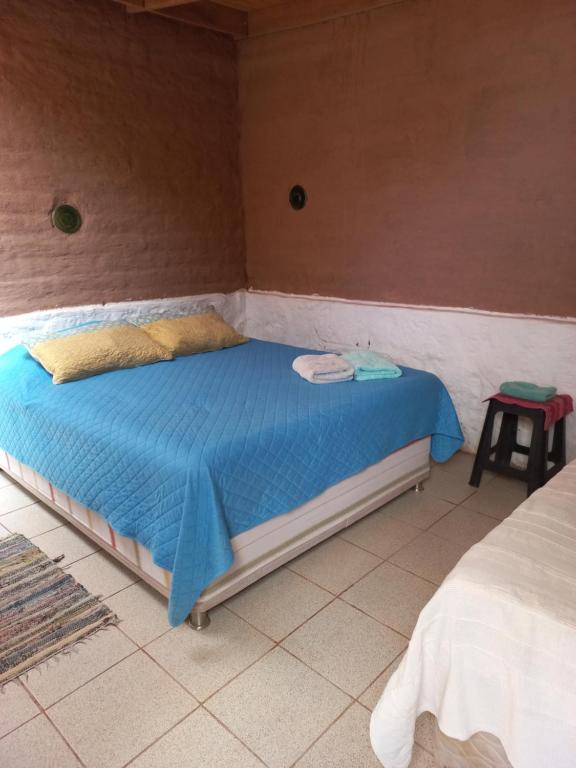 1 dormitorio con 1 cama con edredón azul en Casa Buenavista, en San Pedro de Atacama