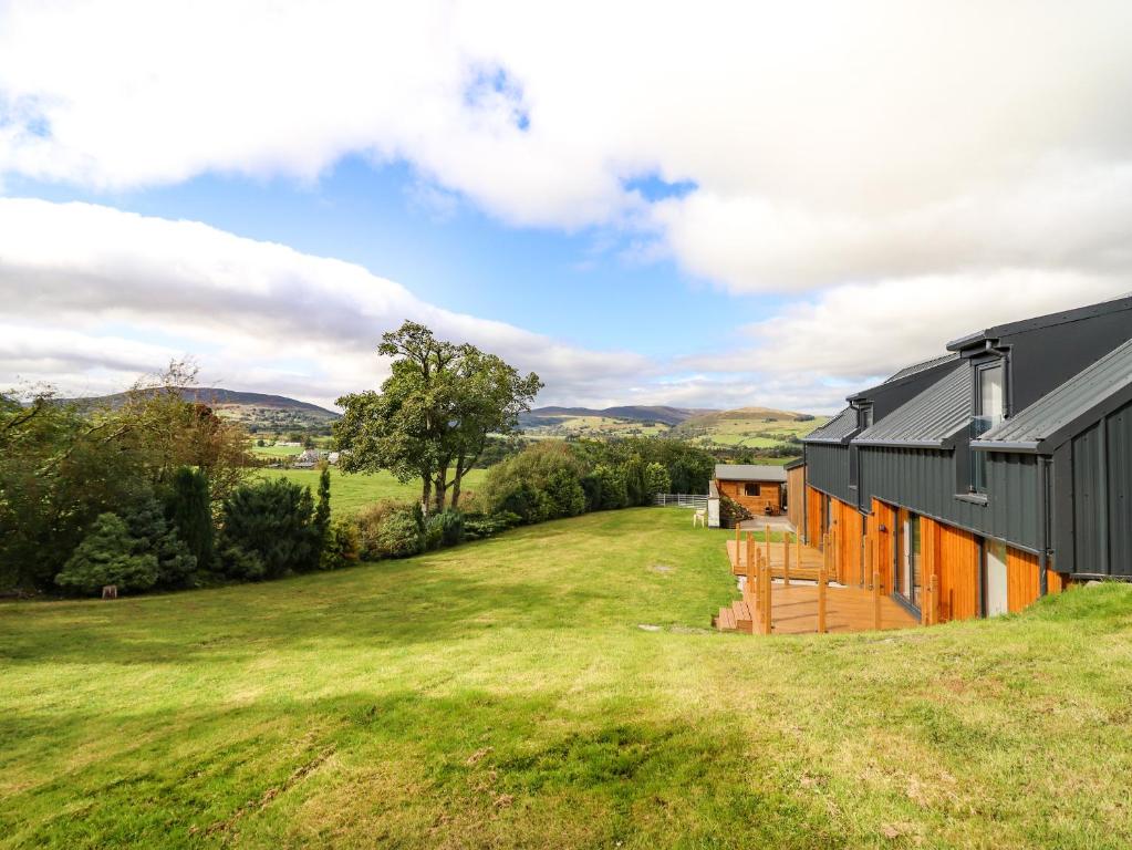 a house with a green yard next to a building at Arenig View in Bala