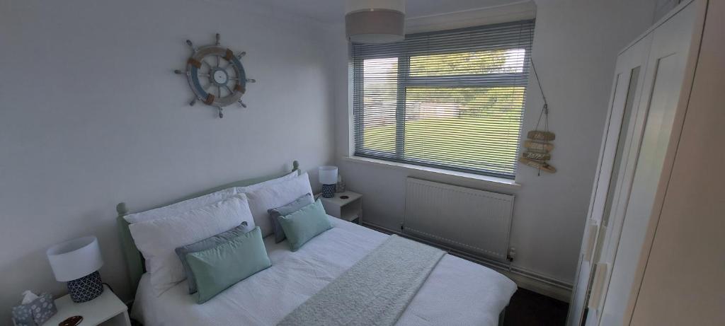 Un dormitorio con una cama blanca con almohadas y una ventana en Rosa Blanca en Sandown