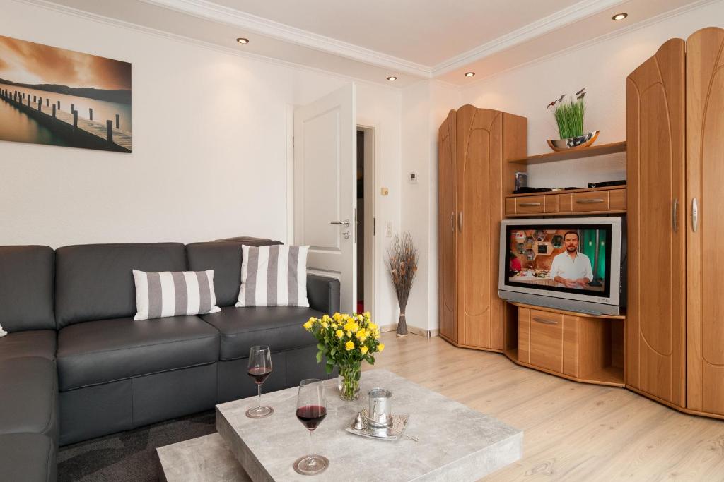 a living room with a couch and a tv at Haus Möwe Wohnung Leuchttürmchen in Hörnum