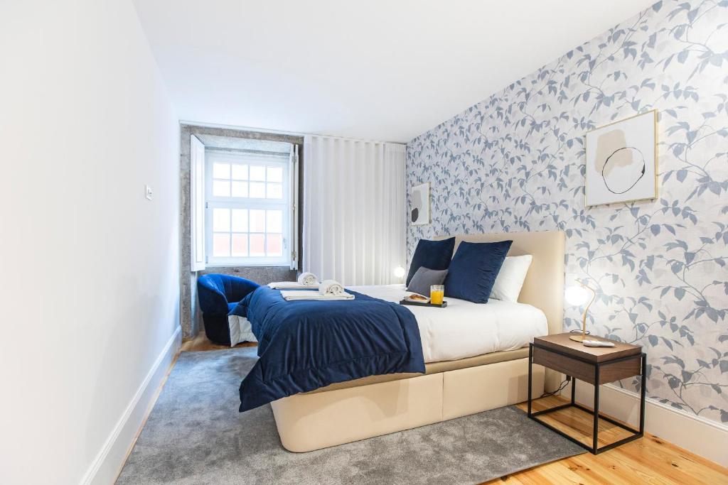 een slaapkamer met een bed met blauw en wit behang bij Elegant Downtown 1BR Flat w/ AC by LovelyStay in Porto