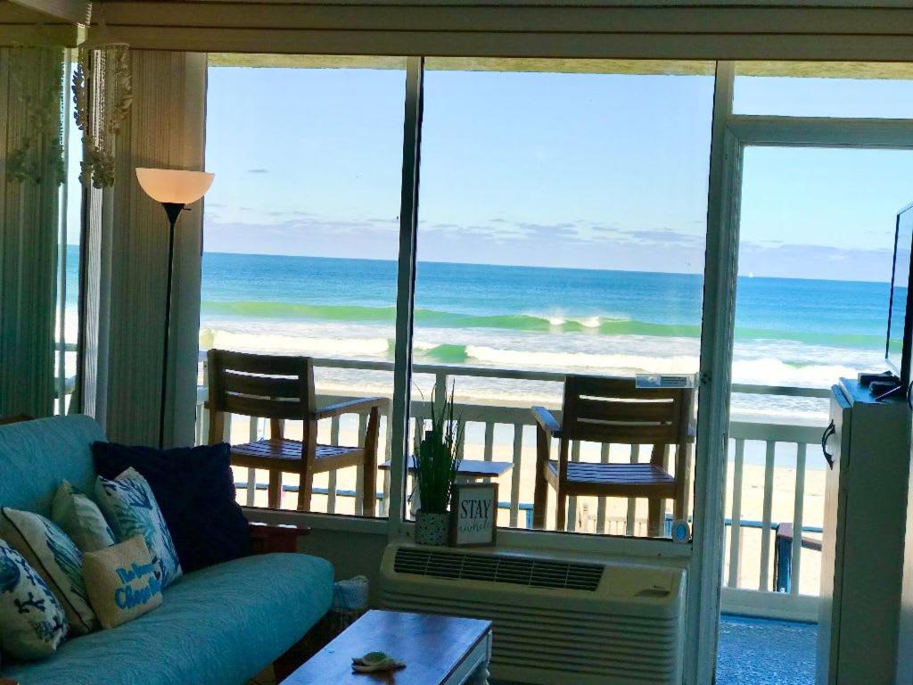 een woonkamer met een bank en uitzicht op de oceaan bij Beach Daze - Ocean front at Symphony Beach Club! in Ormond Beach