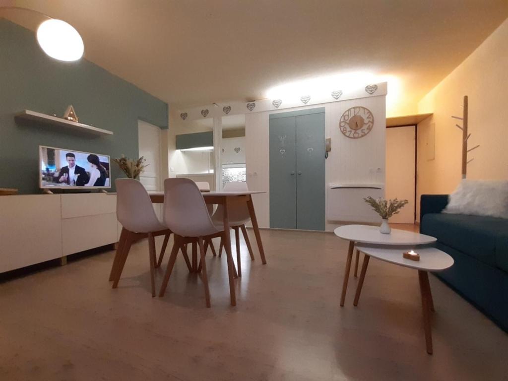 een woonkamer met een tafel en stoelen en een bank bij Au Coeur de Prémanon in Prémanon